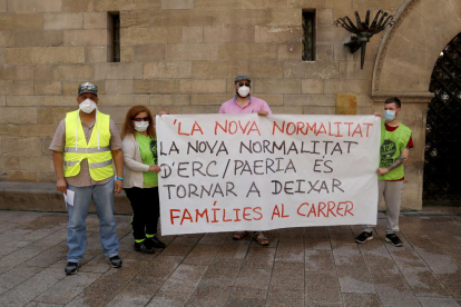 Dues de les persones que es quedaran al carrer el 21 de juny de 2020, la Marta i el Yousef (esquerra), amb altres membres de la PAH, amb una pancarta davant la Paeria.