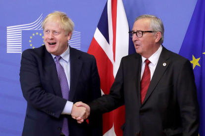 Boris Johnson i Jean-Claude Juncker es donen la mà en l’obertura del Consell Europeu, que es va celebrar ahir.