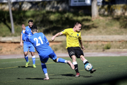 Un jugador del Lleida B conduce el balón ante la presión de un defensa rival.