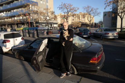 Albert Torruella y su perrita, en el coche en el que pernoctan desde hace unas semanas, ayer. 