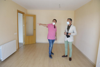 Un agent immobiliari mostra un pis a un client, ahir.