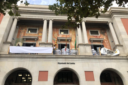 La colocación de la nueva pancarta en la fachada de la Diputación. 