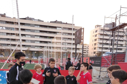 Un entrenador del Atlètic Segre dando una charla en inglés a sus jugadores. Derecha, jugadoras del Club Bàsquet Lleida.