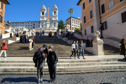 Turistes amb mascareta visiten la plaça Espanya de Roma.