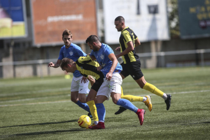Dos jugadores del Alcarràs presionan a un jugador del Montañesa durante el partido de ayer.