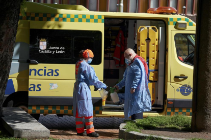 Un equip d'emergències desinfecta els seus elements de protecció després d'atendre una urgència en un carrer d'Àvila
