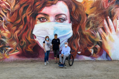 L’artista Lily Brik (centre) davant del seu mural amb l’alcalde, Jordi Latorre, i la regidora Ester Roig.