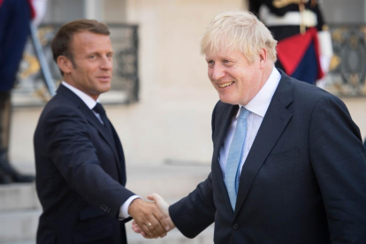 Macron i Johnson es donen la mà després de la reunió.