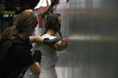 Imagen de una agente de policía identificando a una carterista en el metro de Barcelona, ??el 11 de julio.