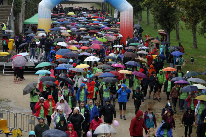 Els participants en la caminada amb motiu del Dia Mundial contra el Càncer de Mama van anar-hi preparats amb paraigües i impermeables per suportar la pluja.