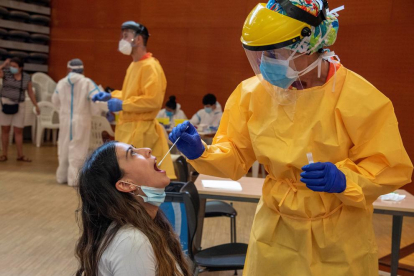 Una jove és atesa per un professional sanitari al Centre Cívic del barri de Balàfia de Lleida, on el departament de Salut ha iniciat aquest divendres cribratges massius de PCR