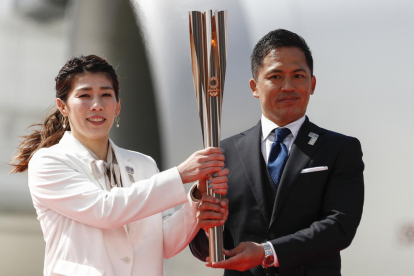 Saori Yoshida i Tadahiro Nomura sostenen la flama olímpica després d’arribar a la ciutat de Matsushima.