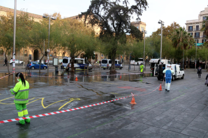 Operarios limpian la zona de la acampada, ayer, en Barcelona.