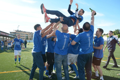 Los jugadores del Alcarràs celebran el campeonato en el césped tras el partido.