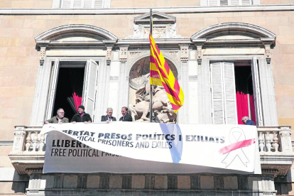 Operaris del Govern instal·lant la nova pancarta sobre l’antiga, ahir a Barcelona.