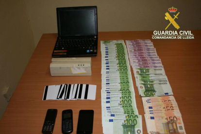 Imagen del material informático, las tarjetas, los móviles y el dinero incautado a los acusados. 