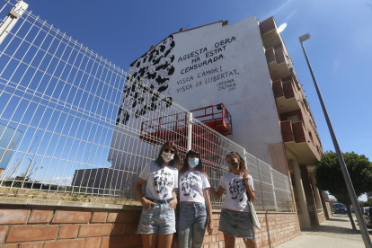 La artista Cristina Dejuan, en el medio, ayer delante del mural censurado en Torrefarrera. 