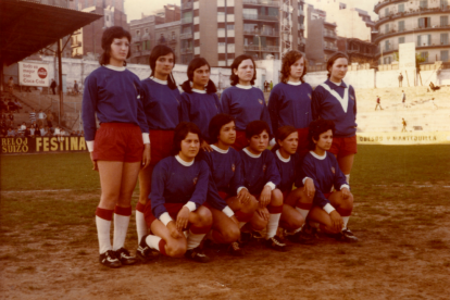 Elena Bobillo, Juanita Sánchez, Amparo Albà, Alexa Berenguer, Maria Molina, Clemente i Enriqueta Palomares (a la fila superior) i a sota Montse Albà, Lourdes, Paquita Jiménez, Glòria Batlle, Dolores Carreño i Pepita Solé, amb la Tribuna del Ca ...