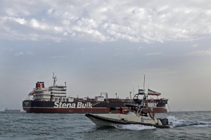 Una lancha iraní pasa junto a un barco en el estrecho de Ormuz. 