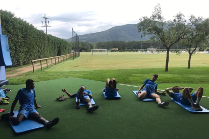 Los jugadores del Lleida estiran después del entrenamiento.