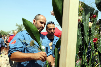 Dos bombers dipositen clavells en l’ofrena floral celebrada diumenge als Graf Lleida que van morir.