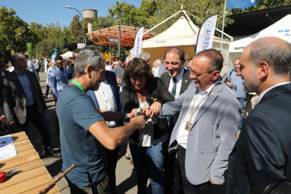 La consellera Jordà prueba en la mano del alcalde Pueyo la efectividad del sistema de seguridad de unas tijeras de podar.