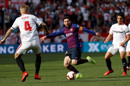Leo Messi, capitán de los azulgranas y autor de tres de los cuatro tantos frente al Sevilla, trata de driblar al defensa local Simon Kjaer.