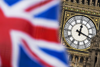 Vista del reloj del Big Ben de Londres entre una bandera del Reino Unido.