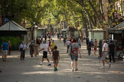 Desenes de persones passegen pel centre de Barcelona.