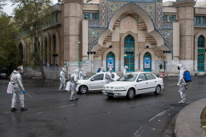 Voluntarios desinfectando una calle en Irán, donde ya han muerto cerca de 2.000 personas.