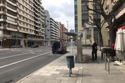 Un operario limpiando una parada de autobús en la avenida Catalunya, ayer al mediodía. 