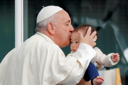 Imatge del papa Francesc besant un nen durant en la visita al Japó.