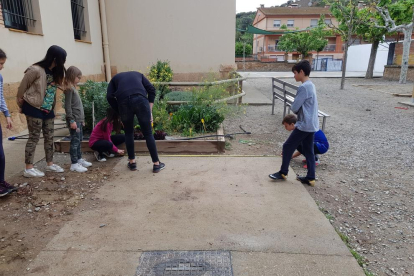 Alumnos de la escuela de Camarasa e internos del centro de Lleida juegan durante un paréntesis en los trabajos de jardín. 