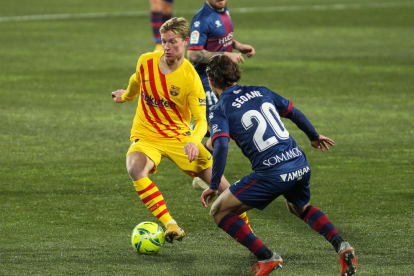 Messi remata ante dos jugadores del Huesca.