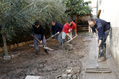 Imagen de un grupo de voluntarios limpiando ayer un jardín de una casa de Arbeca. 