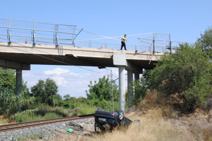 El vehículo rompió la valla de seguridad y acabó volcado en el arcén de las vías del tren. 