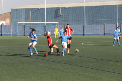 Inés intenta controlar una pilota per a l’AEM davant de dos rivals de l’Athletic B.