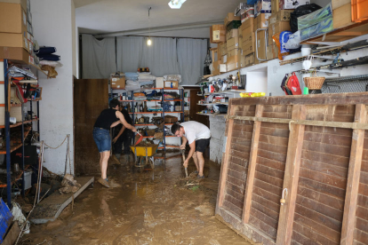 Unos vecinos de Alcanar trabajan para sacar el agua de su casa.