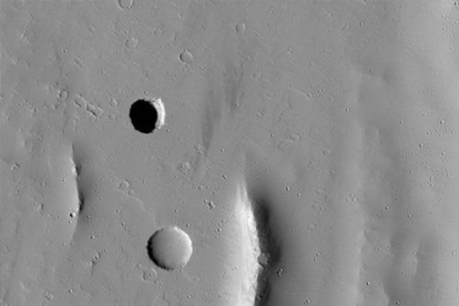Imatge d'un cràter de pou a Mart fotografiat per l'orbitador de la NASA MRO i cedida pel CAB/NASA/JPL/UArizona