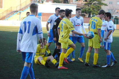 Els jugadors del Mollerussa i el Cambrils, en una acció polèmica després d’una falta, ahir durant el partit al Municipal de Mollerussa.