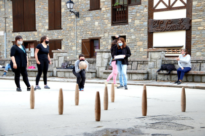 Una jugadora se prepara para hacer una tirada en las ‘bitlles’ pallaresas en las Valls d’Àneu. 