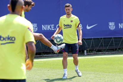 Gerard Piqué controla el balón durante el entrenamiento de ayer, entre Arturo Vidal y Lenglet.