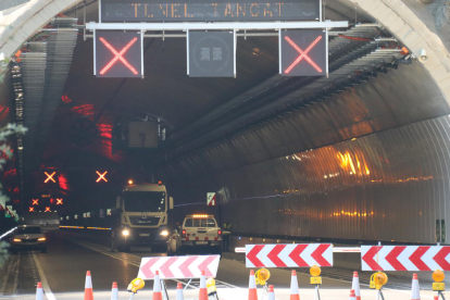 La boca nord del túnel de Tresponts, a la C-14, amb la senyalització del tancament per obres i operaris a l'interior revisant un dels ventiladors