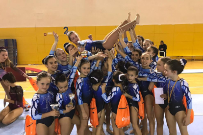 Las gimnastas del Club Gimnàstic FEDAC Lleida levantan a Àngela Mora tras su participación en el Torneo de Esplugues.