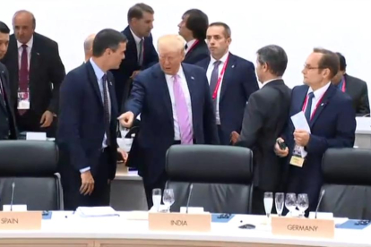 El momento en que Trump señala a Sánchez el lugar en el que debe sentarse en la mesa del plenario.