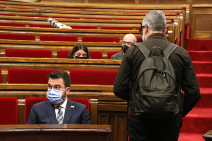 El diputado de la CUP Carles Riera pasa junto a Pere Aragonès en el Parlament.