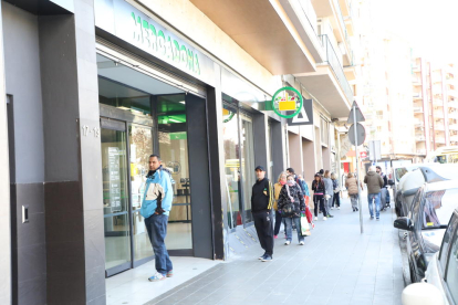 Cola de clientes ayer por la mañana en la puerta de un supermercado en Lleida ciudad. 
