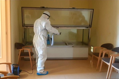 Un tècnic de Milsan desinfectant una sala de vetllatori.