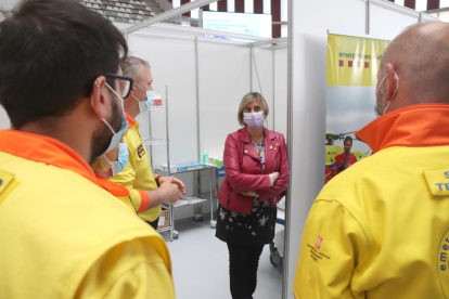 La consellera de Salud, Alba Vergés, conversando con sanitarios en el punto de vacunación masiva del Palau d'Esports Catalunya de Tarragona.