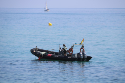 Agents de la Guàrdia Civil, ahir, durant l’examen de l’artefacte trobat a la costa de Badalona.
